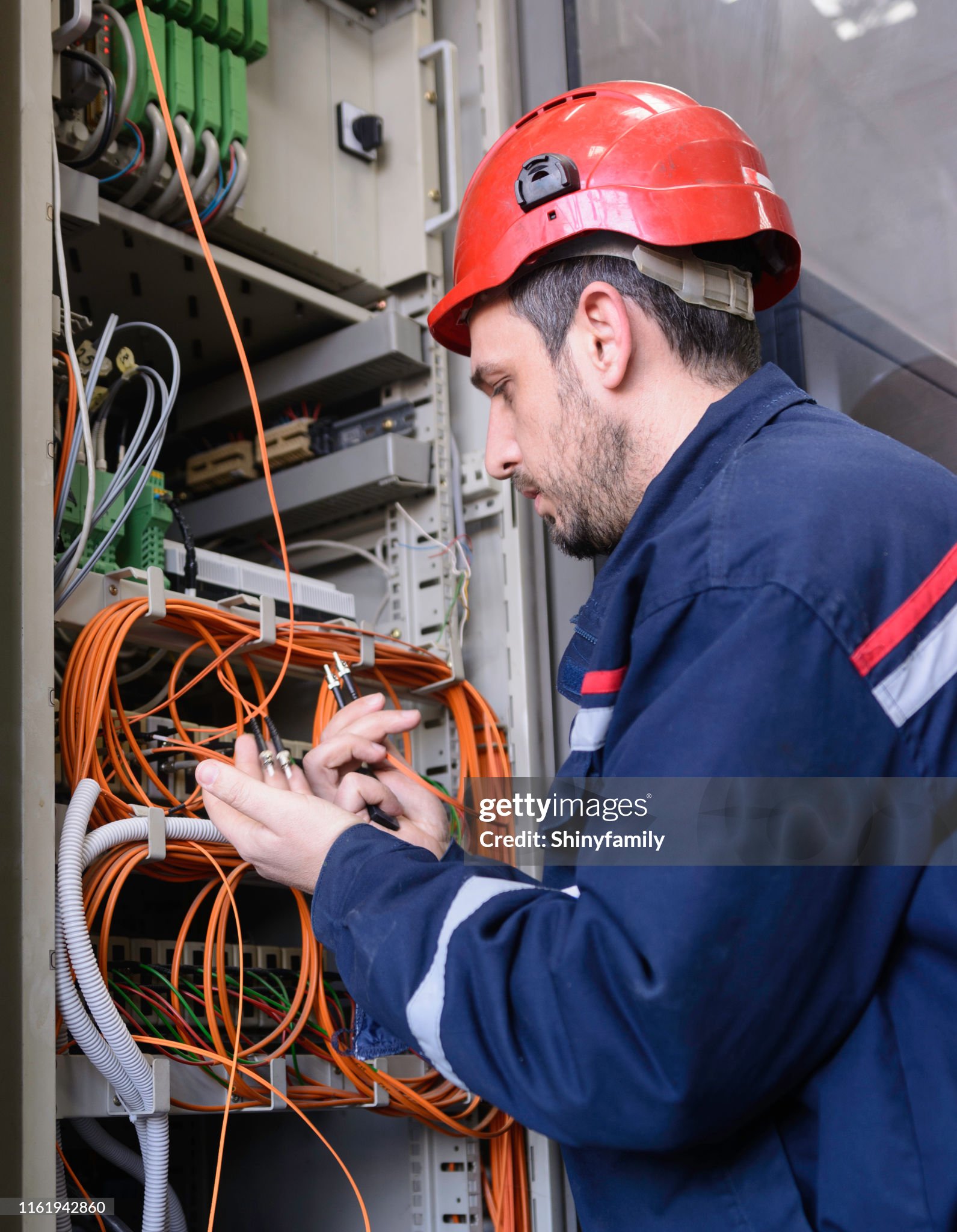 Network technician jumpering fibre optic. Man working in network server room