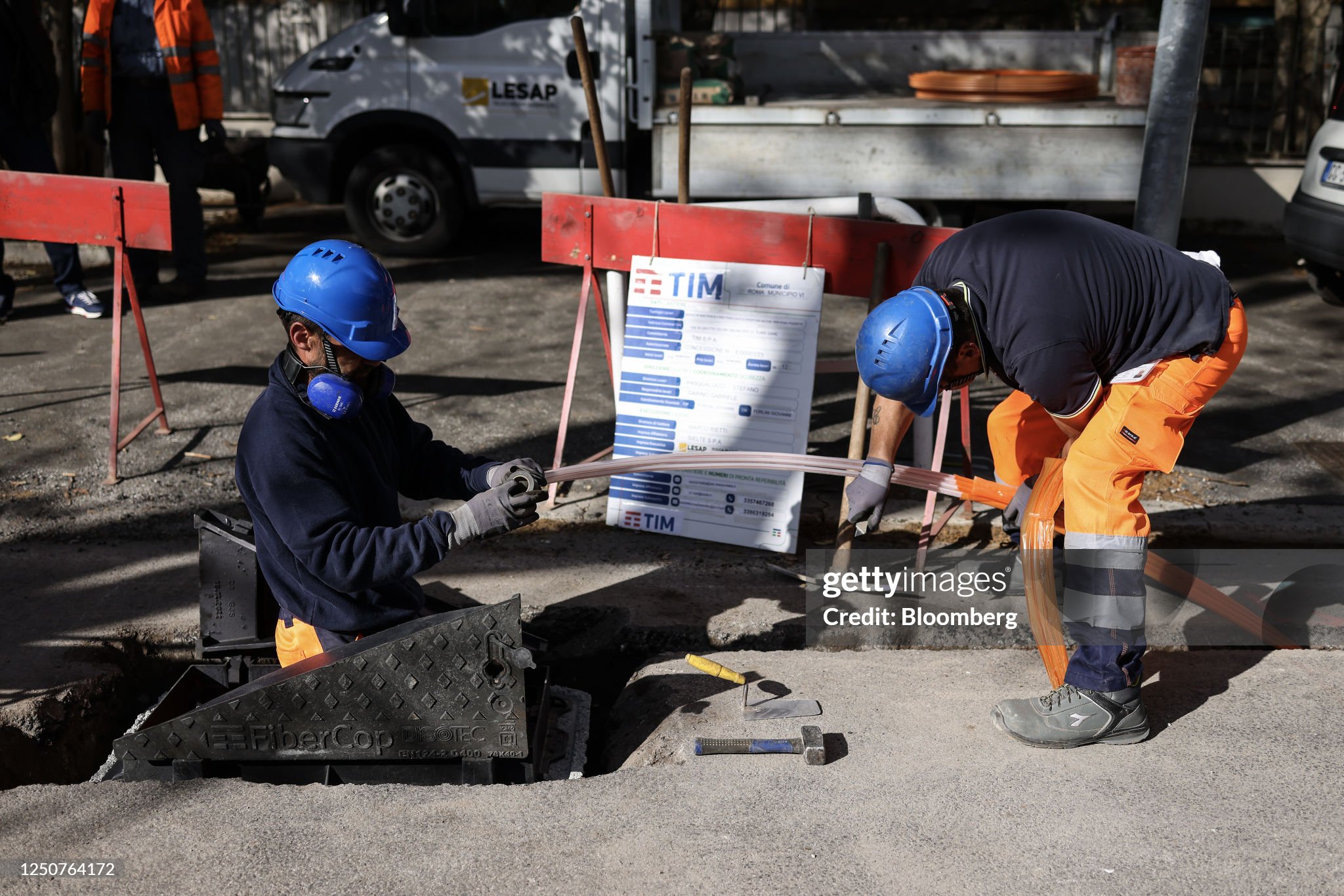 Technicians install fiber optic cables for Telecom Italia SpA in Rome, Italy, on Tuesday, April 4, 2023. Telecom Italia sold 400 million ($435 million) of bonds as it pushes ahead with the sale of its landline network in a bid to slash the companys debt pile after interest rates rose. Photographer: Alessia Pierdomenico/Bloomberg via Getty Images